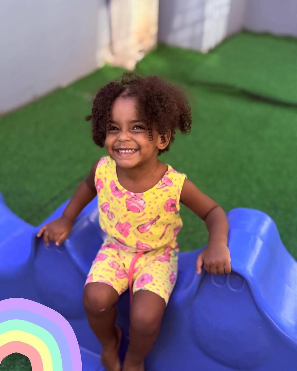 Menina no escorregador do parque da escola